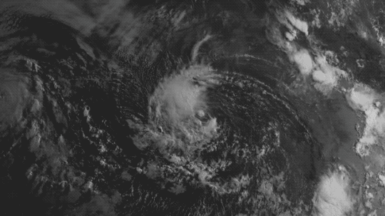 This animation pans in on satellite imagery of the swirl of clouds that was forming into Hurricane Julio. The image is a grayish-blue color with wisps of clouds. In the center is an oval with a faint cloud ring surrounding it and heavy cloud cover on the left side of the oval. An inset square pops up showing one region and marking two spots in purple to show where terrestrial gamma-ray flashes were observed. The inset is dated Aug 2, 2014.