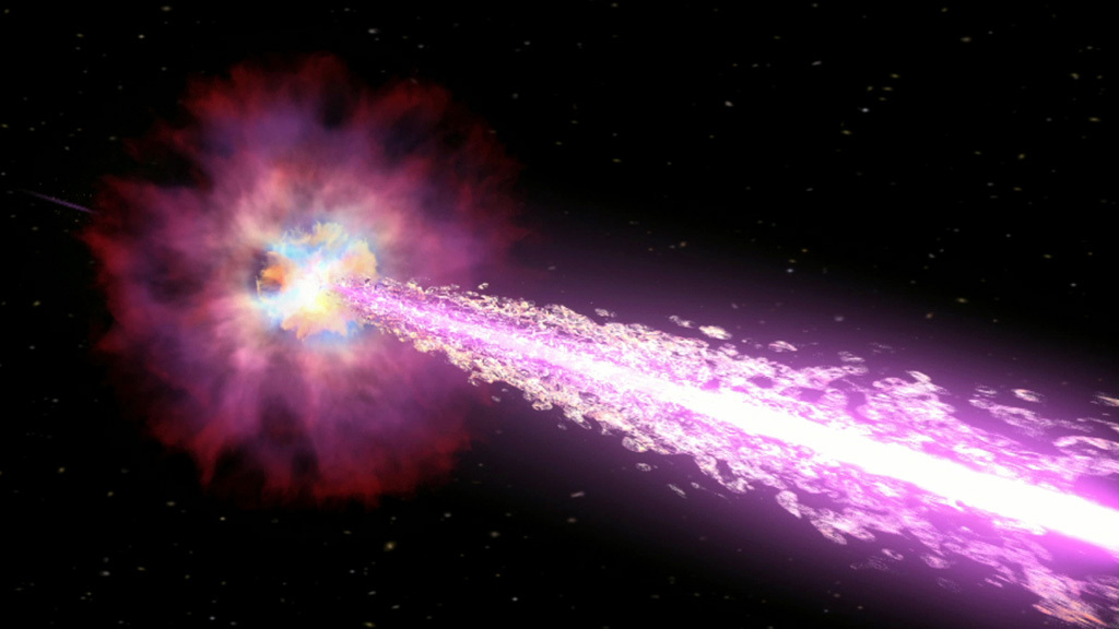 In this illustration, an exploding star powers jets of material. The star is shown as an almost flower-like shape. The purple “petals” represent clouds of material created in the explosion. The bluish-white and yellow center shows where the newly formed black hole begins driving the jets. The core of the jet pointed toward us is whitish and the broader regions are magenta. In the distance, on the far side of the star, you can see the opposite side of the jet disappearing into space.