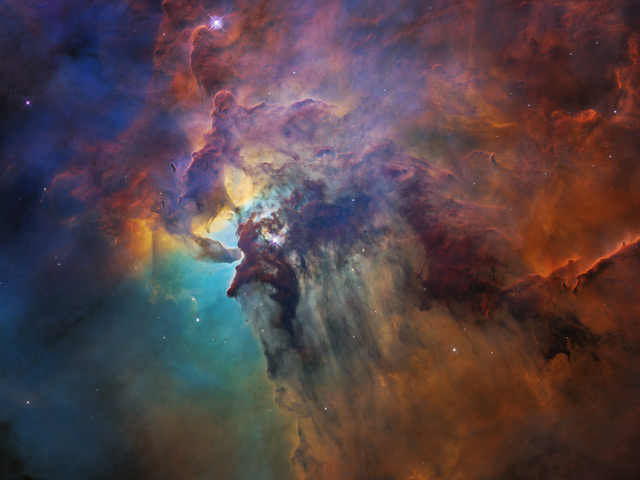 This colorful image, taken by the Hubble Space Telescope, celebrates the Earth-orbiting observatory’s 28th anniversary of viewing the heavens, giving us a window seat to the universe’s extraordinary stellar tapestry of birth and destruction. At the center of this image is a monster young star 200,000 times brighter than our Sun that is blasting powerful ultraviolet radiation and hurricane-like stellar winds, carving out a fantasy landscape of ridges, cavities, and mountains of gas and dust.