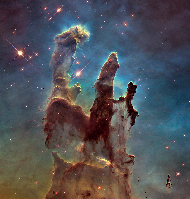 On a background awash in blue and orange cloudy light stands a darker cloud with three pillars rising from it. The edges of the dark regions glow with white and light-blue light.
