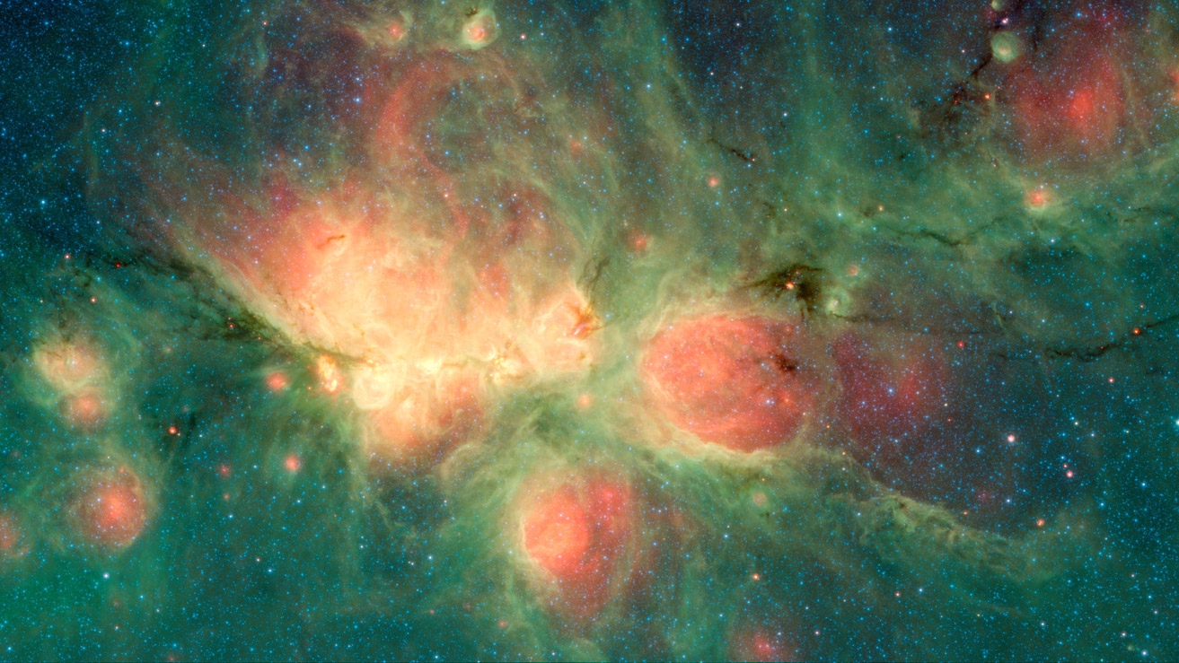 This image shows a starry background bathed in green clouds. At the center is a bright region of yellow and red clouds with two smaller circles of red, taken together these red regions resemble a cat’s footprint.
