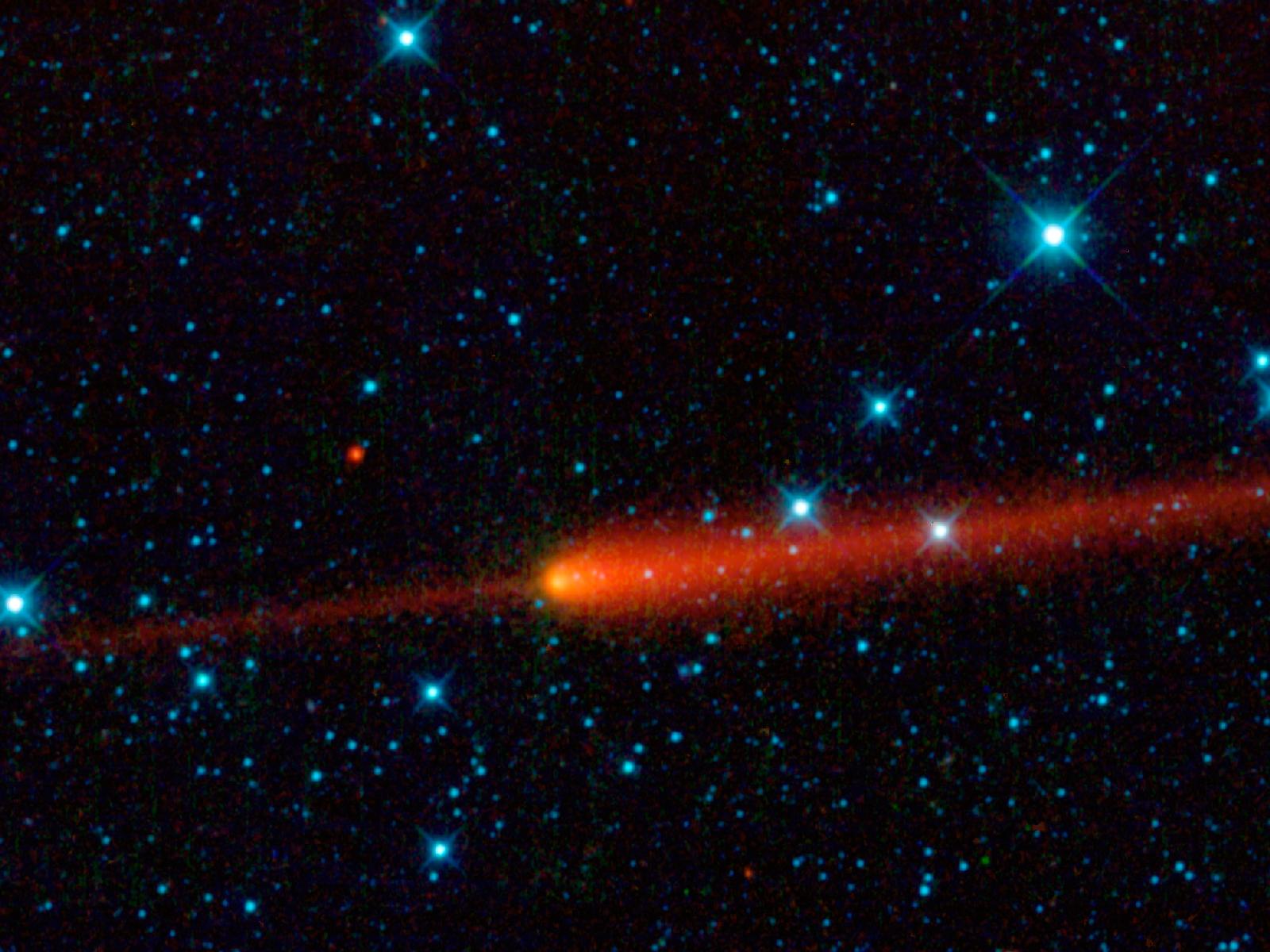Comet 65/P Gunn looks like a match with a flame against a starry background. A thin stripe of red runs from the left side of the image almost to the middle where a bright red and yellow ball flares up with a tail tapering off to the right.