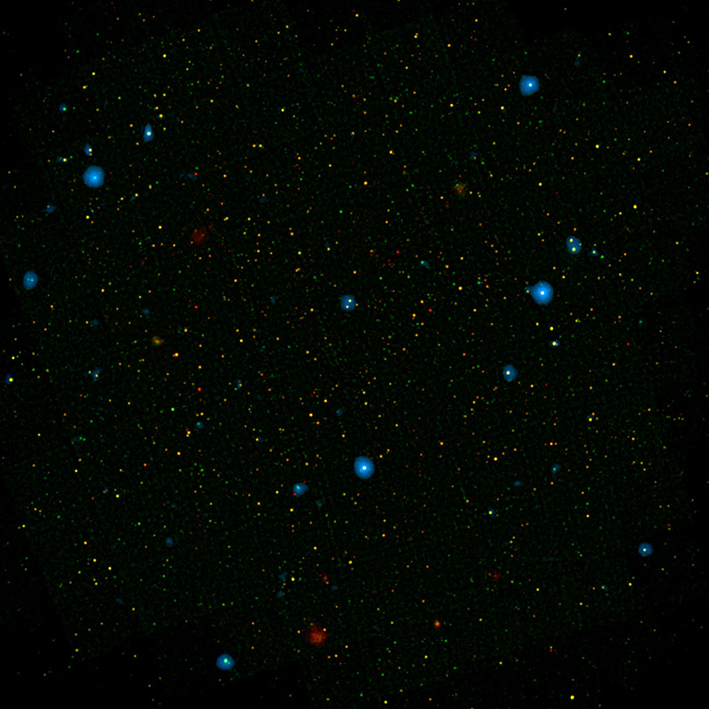 On a field of black there are small yellow and red dots spread across the image. About a dozen larger, blue dots are scattered amongst the smaller, paler sources.